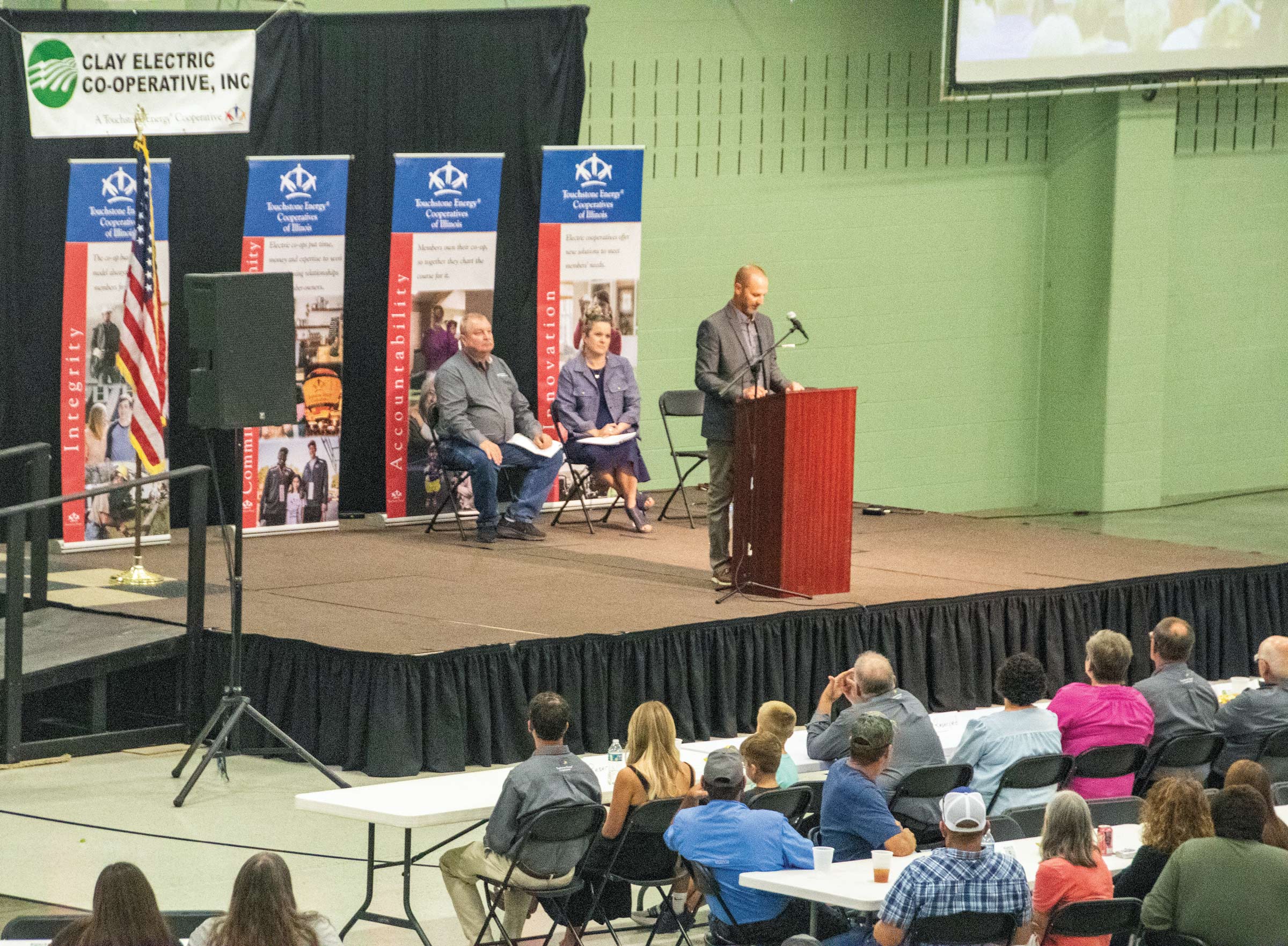 Scene from an annual meeting - a seated crowd faces Clay board members on a stage