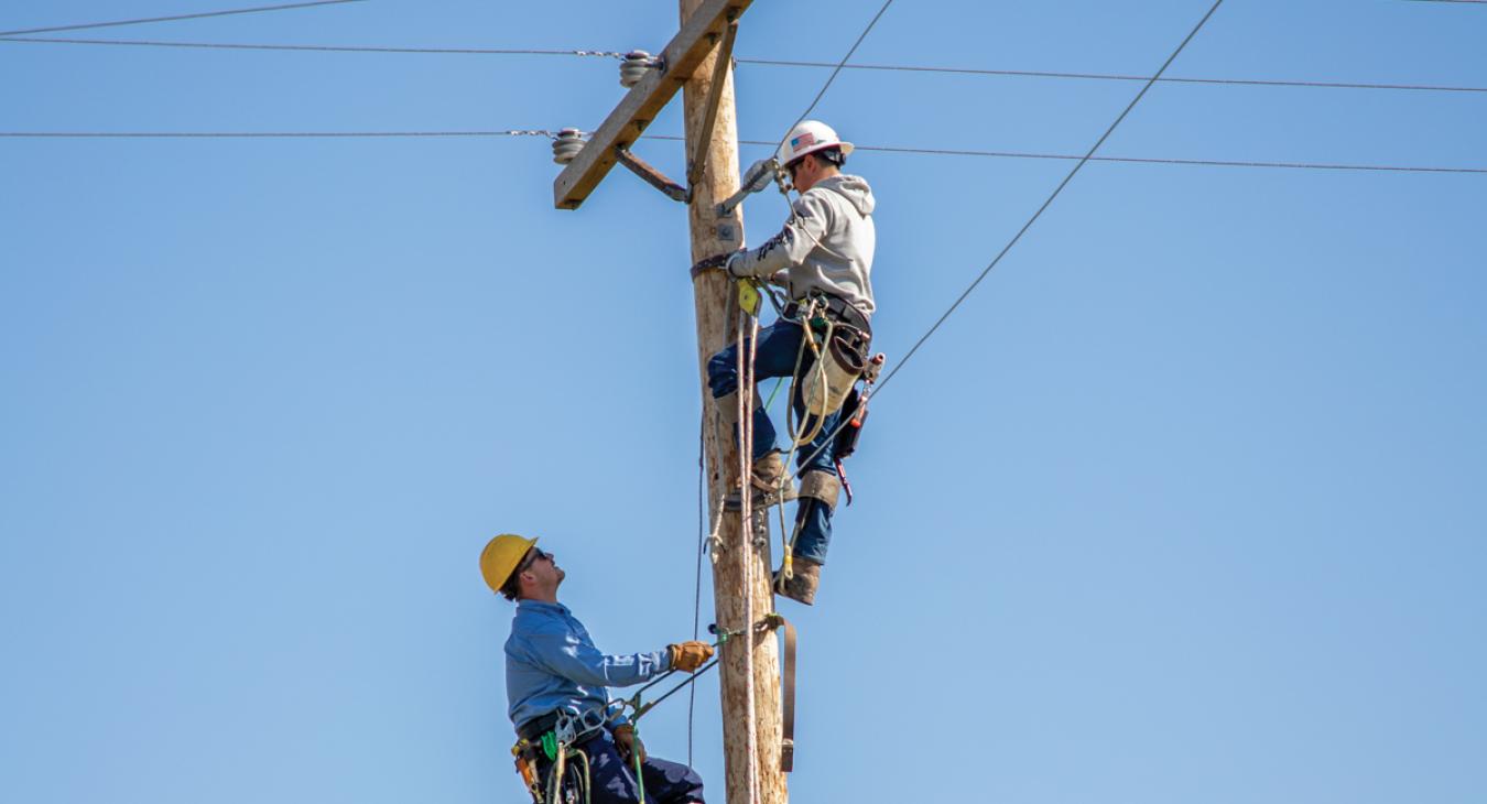 Two lineworkers on a utility pole